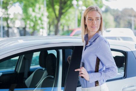 Beautiful young woman with carの写真素材