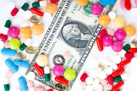 Pills and tablets on white background with dollar bill in vivid colors horizontalの写真素材