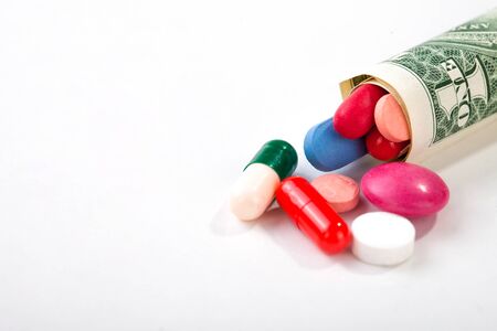Pills and tablets on white background with dollar bill in vivid colors horizontalの写真素材