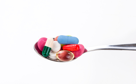 Many colorful pills and tablets in spoonの写真素材