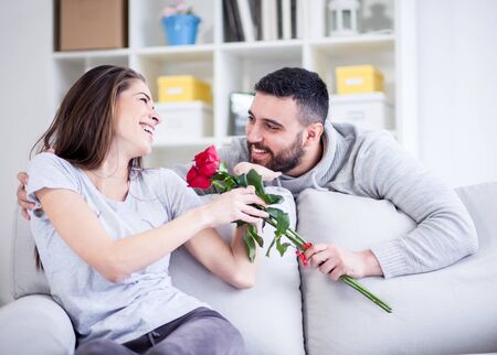 Young man giving a red rose to his girlfriendの写真素材