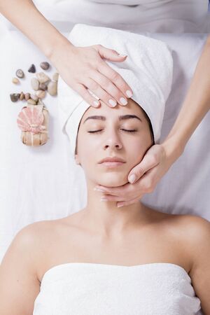Young woman enjoying facial massage at spa salon.Facial massageの写真素材