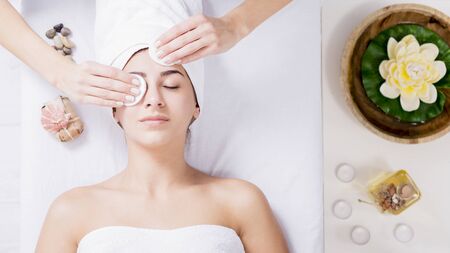 Young woman enjoying facial massage at spa salonの写真素材