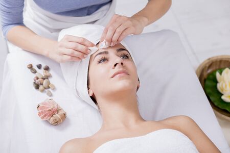 Young woman enjoying facial massage at spa salonの写真素材