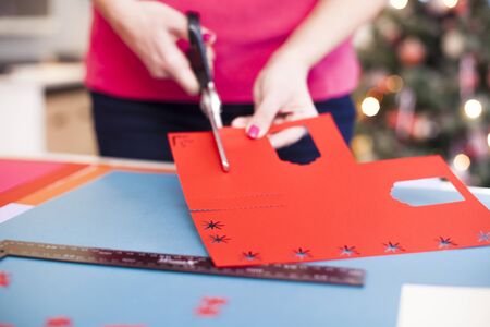 Young woman make scrapbook of the papers on the table using antique tools for cutting paper. Hand made photo album.Shallow depth of fieldの写真素材