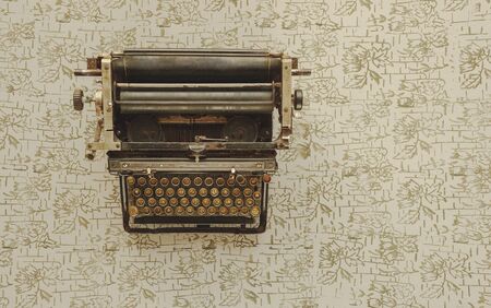 Old typewriter on vintage wooden background photographed in daylightの写真素材