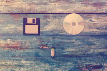 Floppy disk, compact disc and usb flash storage on vintage wood boardの写真素材