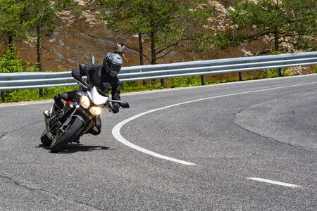 Motorcyclist on an alpine roadの写真素材