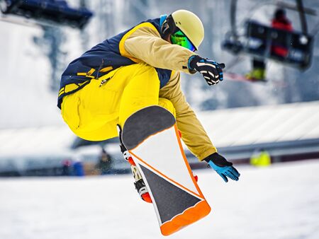 Snowboarder during a trick on a slopeの写真素材
