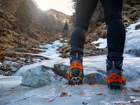 Trekking boots on an iced riverの写真素材