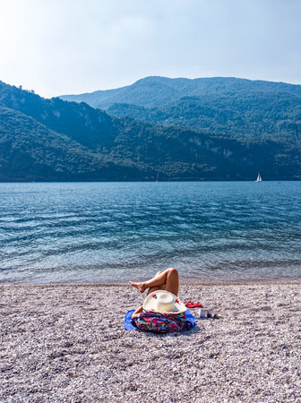 Woman relaxing on a beach of Lake Comoの写真素材