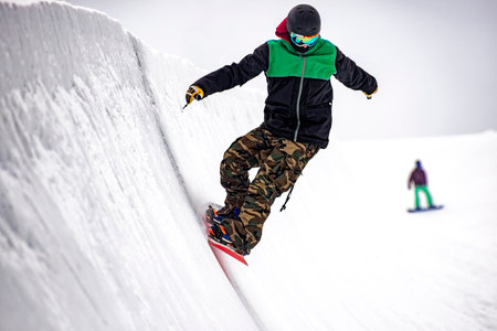 Snowboarder on a half-pipe slopeの写真素材