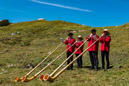 Julierpass (Switzerland) 08/19/2023: A group of typical musicians of Switzerland playing the Swiss horn a typical instrument of the Swiss alps on an alpine pass.のeditorial素材