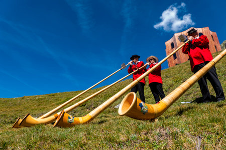 Julierpass (Switzerland) 08/19/2023: A group of typical musicians of Switzerland playing the Swiss horn a typical instrument of the Swiss alps on an alpine pass.のeditorial素材