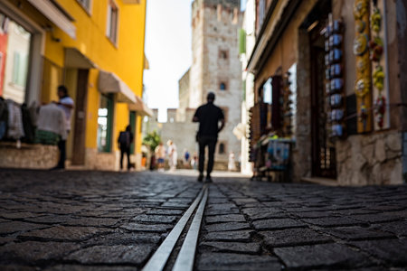 Down view of a man walking in an alley of Sirmione townの写真素材