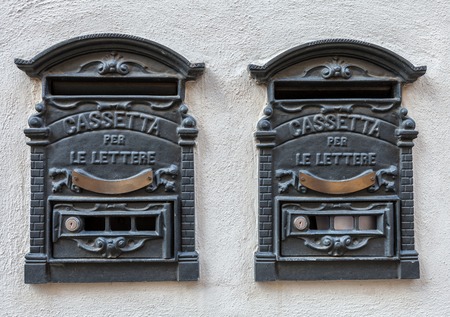 Two traditional Italian iron retro postbox for letters, hanging on the wall of the house.の写真素材
