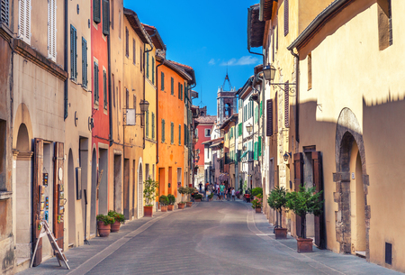 Montepulciano, Italy - August 25, 2013: Old narrow street lined with stone blocks in the center of town with colorful facades. Tourists walking along the street.のeditorial素材
