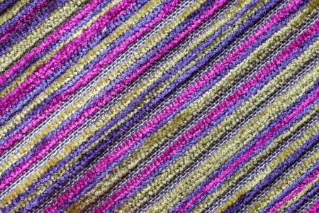 Purple multicolor background of a knitted textile material with diagonal pattern. Fabric with a striped texture closeup.の写真素材