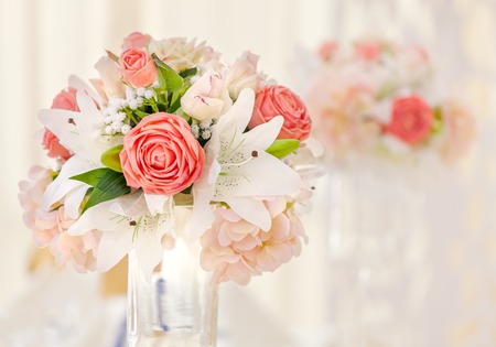 Served table for event dinner, decorated with floral compositions in vases in pink and coral shades. Wedding bouquetの写真素材