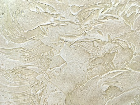 Texture decorative beige plaster imitating the old peeling wall. Obsolete sand cracked background, closeupの写真素材