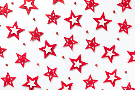 Christmas pattern of red stars on a white wooden background. Backdrop for New Year greeting card.