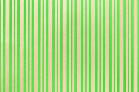 Dark green and golden background from wrapping paper with a pattern of line closeup. Texture of holiday striped paper surface. Backdrop of olive textile.の写真素材