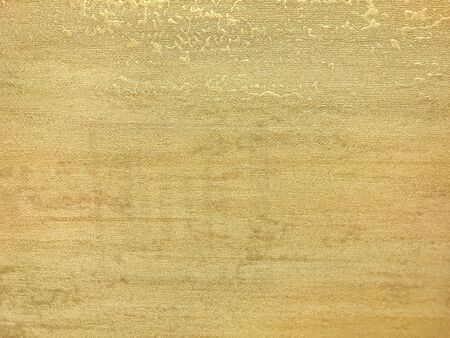 Texture of light yellow wallpaper with a curly glossy pattern. Golden paper surface, structure...