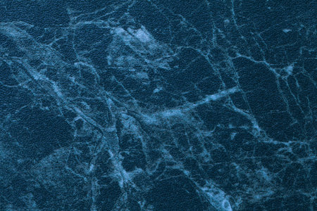 Texture of navy blue marble for tabletop with light lines of pattern, macro background. Artificial stone countertop from mineral tile for covering table on kitchen, abstract backdrop closeup.の写真素材