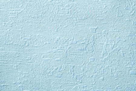 Texture of light blue wallpaper with relief and corrugated pattern. Paper denim background with modern design. Surface closeup.の写真素材