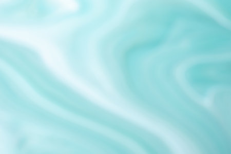 Blurred light blue and white background with wavy lines pattern. Defocused art abstract turquoise gradient backdrop with blur and bokeh. Cyan silk textile.の写真素材