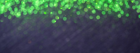 Navy blue blurred background with green lights bokeh for Christmas greeting card and site header with copy space. Black New Year defocused and blurry blackboard. Glittering backdropの写真素材