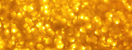 Blurred yellow sparkling background from sequins, macro. Shiny golden glittery bokeh of Christmas...