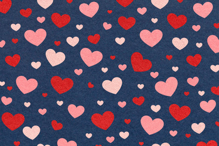 Red and pink hearts pattern on dark blue textured paper background for romantic design or Valentines...