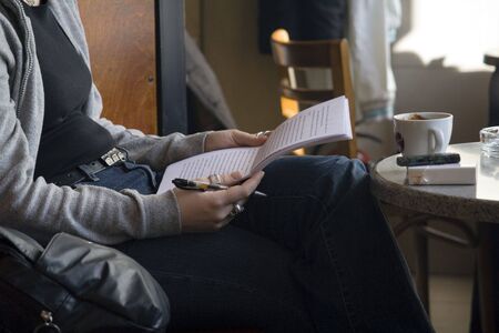 Young woman reading at the cafeの写真素材
