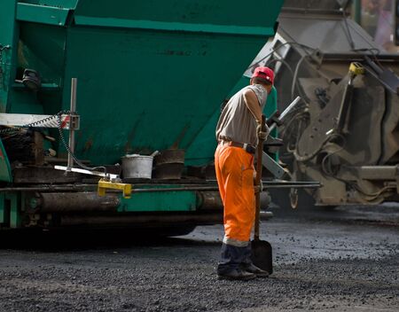 Road workers at the asphalt repairing worksの写真素材