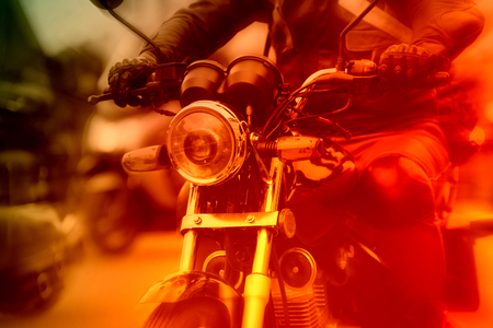 Motorcycle rider rushing at city street, colorized imageの写真素材