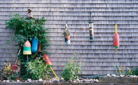 Buoys Hang on a Wall with Bird Feedersの写真素材