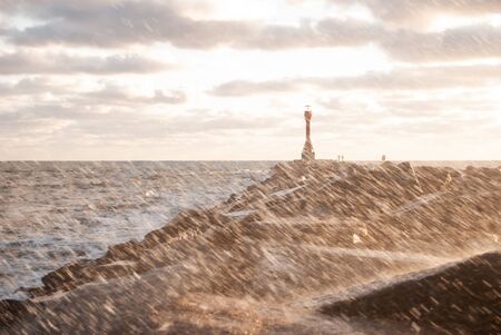 Sun Shower on a Jetty with a Lighthouseの写真素材