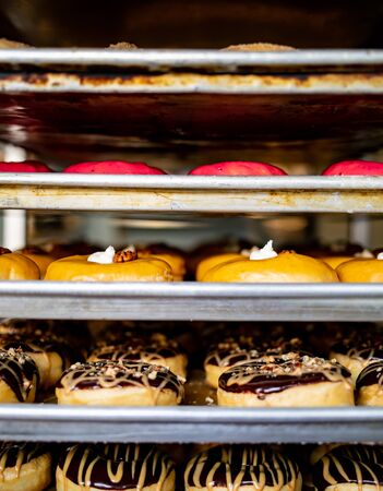 Rows of metal baking trays filled with vegan donuts ready to be sold in the morning.