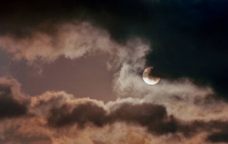 The round sun behind cloud cover with a dark and scary sky.の写真素材