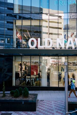 A Person Walks Past a Shopping Center in Downtown Boston