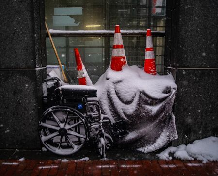 Cones Atop a Wheelchair and Tarp Along a Sidewalk