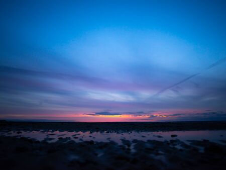 Bright colors in the sky and reflections on the sand make up a watercolor effect.