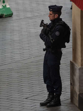 Toulouse France, January 29th, 2020, A uniformed policeman stands guard at a central square with a...