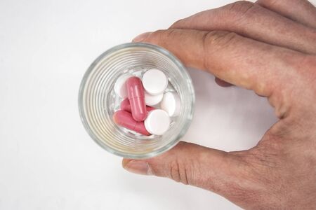 many different colored pills isolated on white background