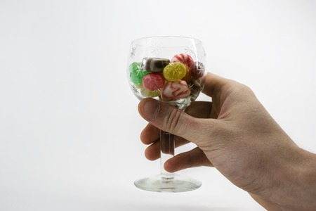 Images of colored caramel sweets in glass vase, image isolated on a white backgroundの写真素材