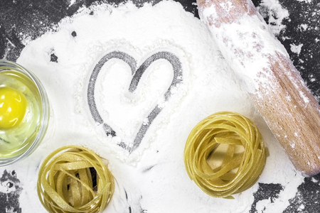 Raw homemade pasta and ingredients for pasta on wooden backgroundの写真素材