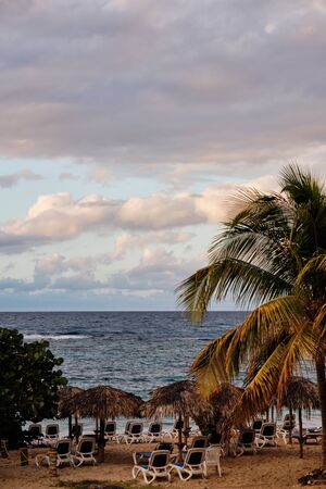 Sunset at the Caribbean sea with abandoned chairsの写真素材