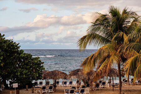 Sunset at the Caribbean sea with abandoned chairsの写真素材