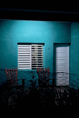 Turquoise building facade with white door and windowsの写真素材
